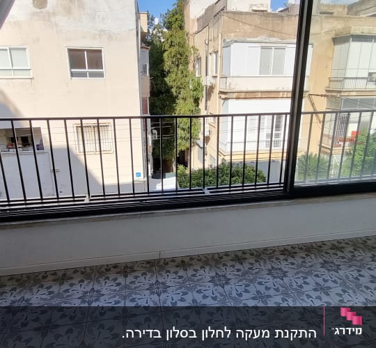 חלון גדול עם מסגרת שחורה ווילונות לבנים
